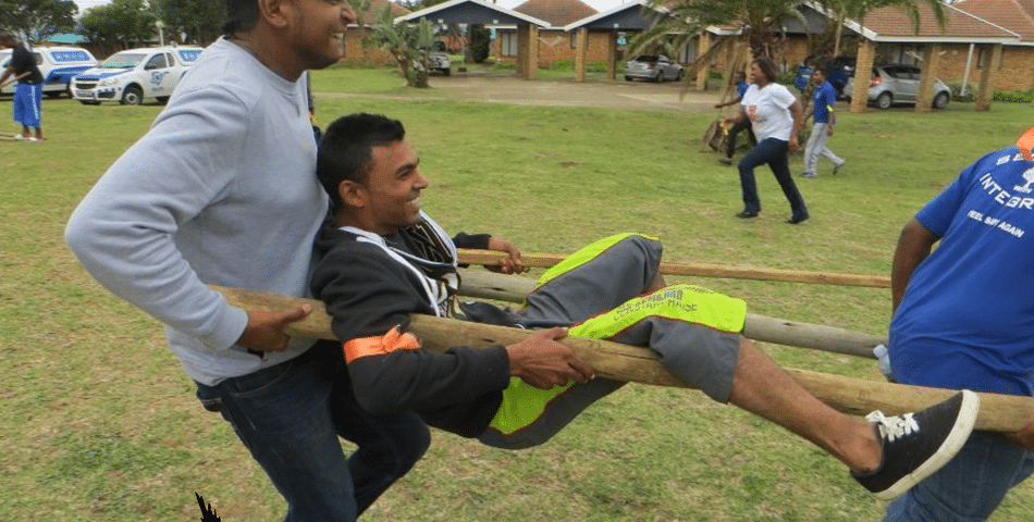team members carrying a man